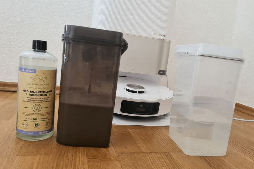 Grashüpfer probiotischer Öko-Tankerfrischer Flasche steht neben dem Schmutzwassertank eines Wischroboters im Test